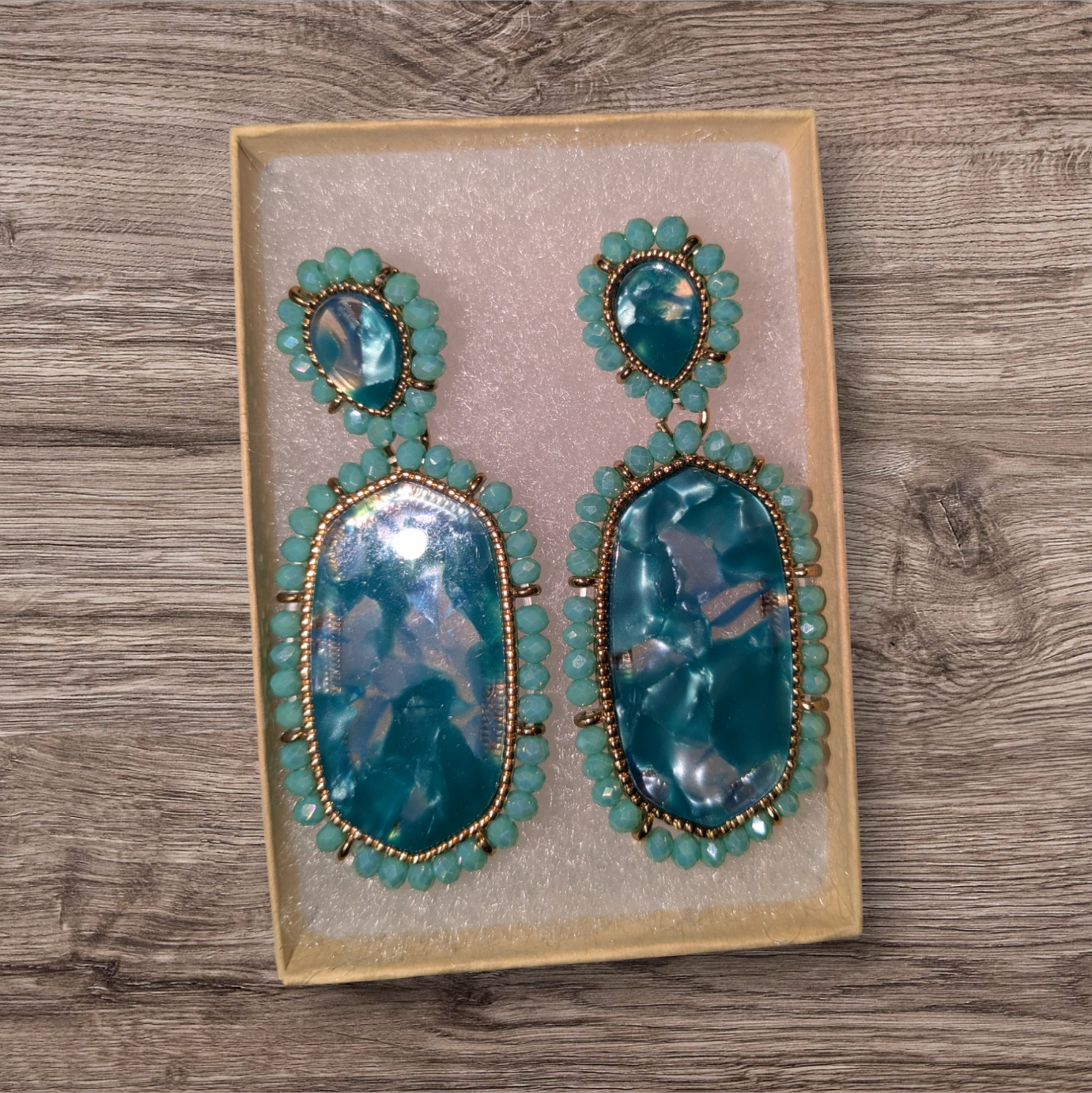 Blue resin drop earrings with beaded edging.