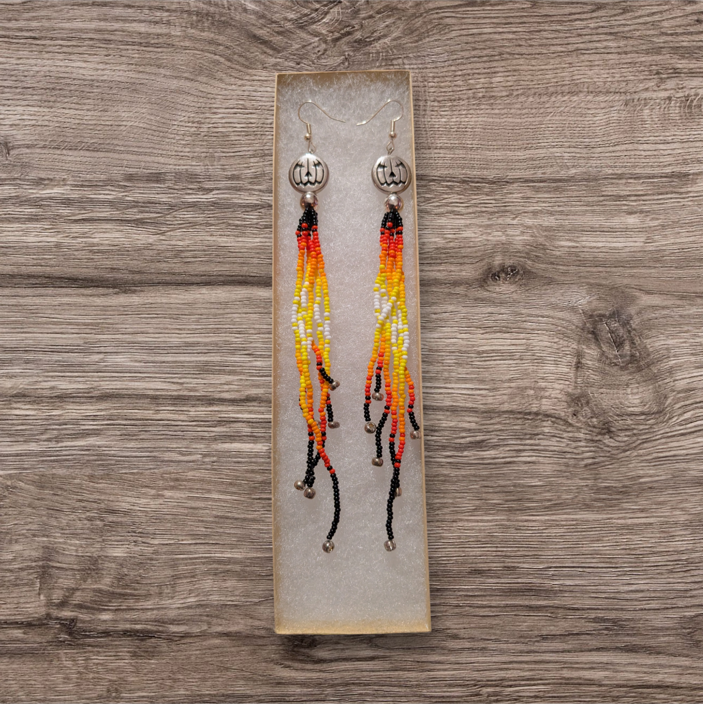 Long silver pumpkin dangle earrings with beaded fringe.