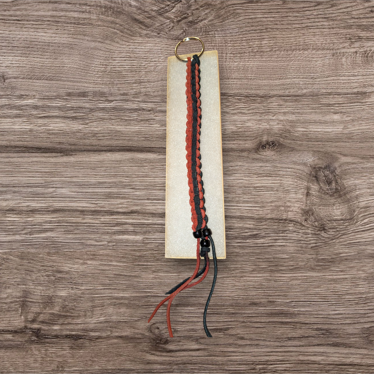 Long, brick red and black box braided leather keychain.